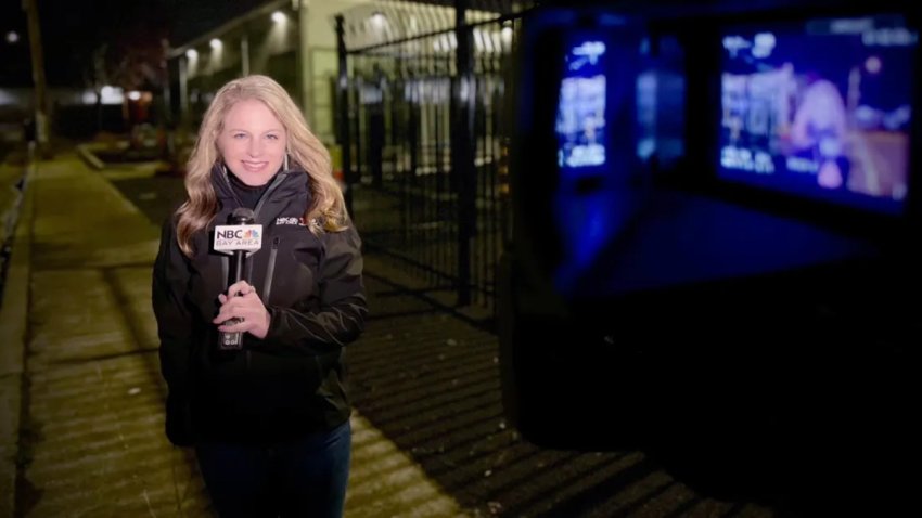 Freelance NBC Bay Area reporter Emma Goss stands with a microphone in front of the camera before a live shot.