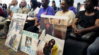 The families of Michael Corey Jenkins and Damien Cameron sit together during the Justice Department’s Civil Rights Division tour Thursday, June 1, 2023, in during a Jackson, Miss. Six white former law enforcement officers in Mississippi who called themselves the “Goon Squad” pleaded guilty Thursday, Aug. 3, 2023, to a racist assault on the two Black men in a home raid that ended with an officer shooting one man in the mouth.