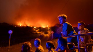 Local residents try to reach their houses in Benijos village as police block the area as fire advances in La Orotava in Tenerife, Canary Islands, Spain on Saturday, Aug. 19, 2023. Firefighters have battled through the night to try to bring under control the worst wildfire in decades on the Spanish Canary Island of Tenerife, a major tourist destination. The fire in the north of the island started Tuesday night and has forced the evacuation or confinement of nearly 8,000 people.