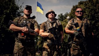 Ukrainian soldiers pose for a photo in front of the Ukrainian flag on August 22, 2023 in Kramatorsk, Ukraine. 