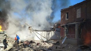 In this photo provided by the Ukrainian Emergency Service, people work to extinguish a fire following a Russian attack in Kryvyi Rih, Ukraine, Friday, Sept. 8, 2023.