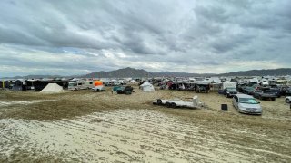 Camps are set on a muddy desert plain on September 2, 2023, after heavy rains turned the annual Burning Man festival site in Nevada’s Black Rock desert into a mud pit. Tens of thousands of drenched festivalgoers were stranded on September 3, 2023, in deep, sticky mud in the Nevada desert after torrential rain turned the annual Burning Man gathering into a quagmire. All events at the counterculture festival, which drew some 70,000 people, were canceled after rain tore down structures for dance parties, art installations and other eclectic entertainment. (Photo by Julie JAMMOT / AFP) (Photo by JULIE JAMMOT/AFP via Getty Images)