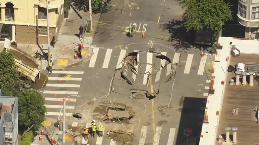 Crews in San Francisco work at the scene of a water main break and sinkhole.