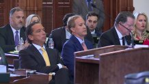 Ken Paxton, center, sits in the Texas Senate chamber with defense attorney Tony Buzbee on the left. 