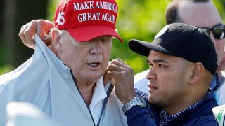 Walt Nauta, personal aide to former U.S. President Donald Trump who faces charges of being Trump’s co-conspirator in the alleged mishandling of classified documents, fixes Trump’s collar before a LIV Golf Pro-Am golf tournament at the Trump National Golf Club in Sterling, Virginia, U.S. May 25, 2023. 