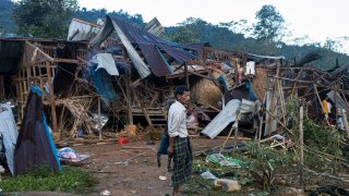 A man looks on at homes destroyed after air and artillery strikes in Mung Lai Hkyet displacement camp, in Laiza, Myanmar, Tuesday Oct. 10, 2023.