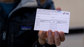 FILE - A nurse practitioner holds a COVID-19 vaccine card at a New York Health and Hospitals vaccine clinic in the Brooklyn borough of New York on Jan. 10, 2021.