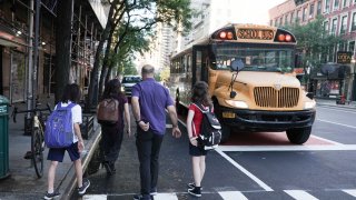 UNITED STATES -September 7: Maureen Teo and her son Reis Teo, 11, walk to the school bus to the Dwight School along with another student and parent Thursday, Sept. 7, 2023 in Manhattan, New York.