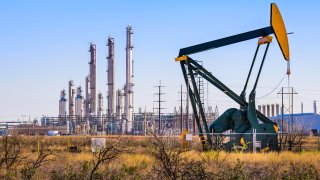 A pumpjack (oil derrick) and oil refinery in Seminole, West Texas.