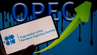 A photo illustration of the OPEC logo seen on a cell phone set against a green arrow in Brussels, Belgium on September 10, 2023.