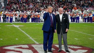 Republican presidential candidate and former President Donald Trump gestures with South Carolina Gov. Henry McMaster