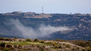 A plum of smoke rises following Israeli artillery shelling on the outskirts of Aita al-Shaab