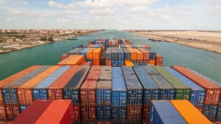 Loaded containers stacked on top of a cargo ship sailing in a canal on Janvier 20, 2017 in Suez Canal, Red sea, Egypt. 