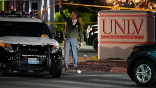 A police officer walks under crime scene tape in the aftermath of a shooting at the University of Nevada, Las Vegas.