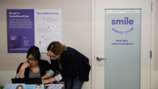 FILE – Dental assistants go over appointments at SmileDirectClub’s SmileShop located inside a CVS store April 24, 2019, in Downey, Calif.