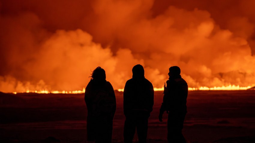 People watch as the night sky is illuminated caused by the eruption.