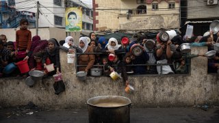 Palestinians line up for a free meal in Rafah