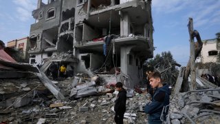 Palestinians inspect the rubble of a building of the Al Nawasrah family destroyed in an Israeli strike in Maghazi refugee camp, central Gaza Strip, Monday, Dec. 25, 2023.