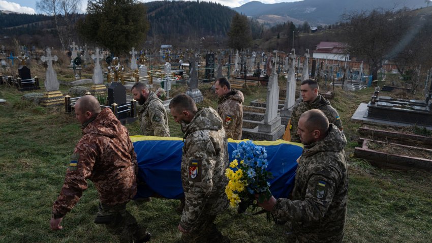 Ukrainian servicemen carry the coffin of their comrade Vasyl Boichuk who was killed in Mykolayiv in March 2022, during his funeral ceremony at the cemetery in Iltsi village, Ukraine, Tuesday, Dec. 26, 2023.