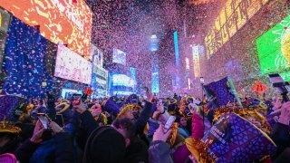 Revelers celebrate New Year’s Eve in Times Square as confetti falls