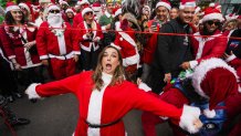 People dressed in Santa Claus costumes play limbo as they participate in SantaCon on December 9, 2023 in New York City. (Photo by Craig T Fruchtman/Getty Images)