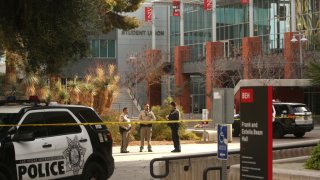 Police officers stand in front of the Student Union a day after three people died