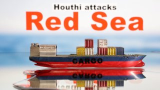 A cargo ship boat model is seen in front of “Red Sea” and “Houthi attacks” words in this illustration taken January 9, 2024. 