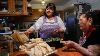 Noelia Sanchez, center, and her mother Aurora Sandoval make tamales together