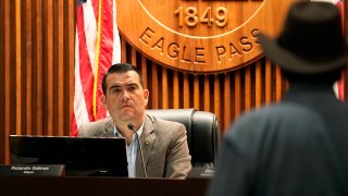 FILE - Eagle Pass Mayor Rolando Salinas, left, listens to Kayak outfitter Jessie Fuentes, right, during a city council meeting in Eagle Pass, Texas, July 6, 2023.