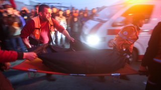 Palestinians remove a body from a car that was hit by an Israeli airstrike in Rafah, Gaza Strip, Saturday, Jan. 20, 2024.