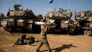 Photo of Israeli soldier carrying tank ammunition.