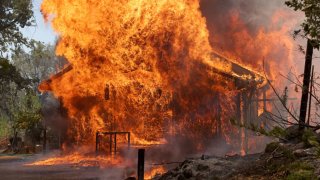 A home burn as the Oak Fire burns through the area on July 23, 2022 near Mariposa, California.