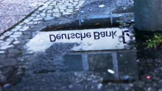 The reflection of a Deutsche Bank AG logo outside a bank branch in Berlin, Germany, on Monday, March 27, 2023.
