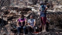 Locals take a break as they clean the rubble of burnt-out houses after forest fires reached their neighborhood in Vina del Mar, Chile, Sunday, Feb. 4, 2024. (AP Photo/Cristobal Basaure)