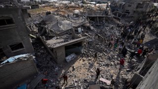 Palestinians inspect the damage to residential buildings where two Israeli hostages were reportedly held before being rescued during an operation by Israeli security forces in Rafah, southern Gaza Strip, Monday, Feb. 12, 2024.