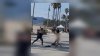 Club-wielding naked woman gets into fight on Venice Beach boardwalk as stunned onlookers film brawl