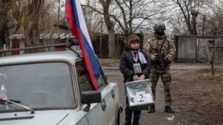 A member of a local election commission, accompanied by a serviceman, visits voters during early voting in Russia’s presidential election in Donetsk, Russian-controlled Ukraine, amid the Russia-Ukraine conflict on March 14, 2024.