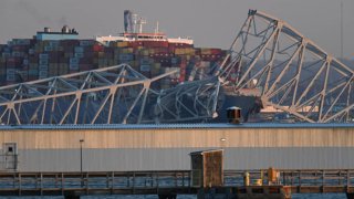 The steel frame of the Francis Scott Key Bridge sits on top of a container ship after it struck the bridge in Baltimore, Maryland, on March 26, 2024. 