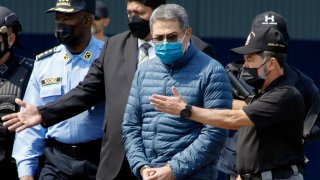 FILE - Former Honduran President Juan Orlando Hernandez, second from right, is taken in handcuffs to a waiting aircraft as he is extradited to the United States, at an Air Force base in Tegucigalpa, Honduras, April 21, 2022. Hernández has been convicted in New York, Friday, March 8, of charges that he conspired with drug traffickers, his military and police to enable tons of cocaine to make it unhindered into the United States. (AP Photo/Elmer Martinez, File)