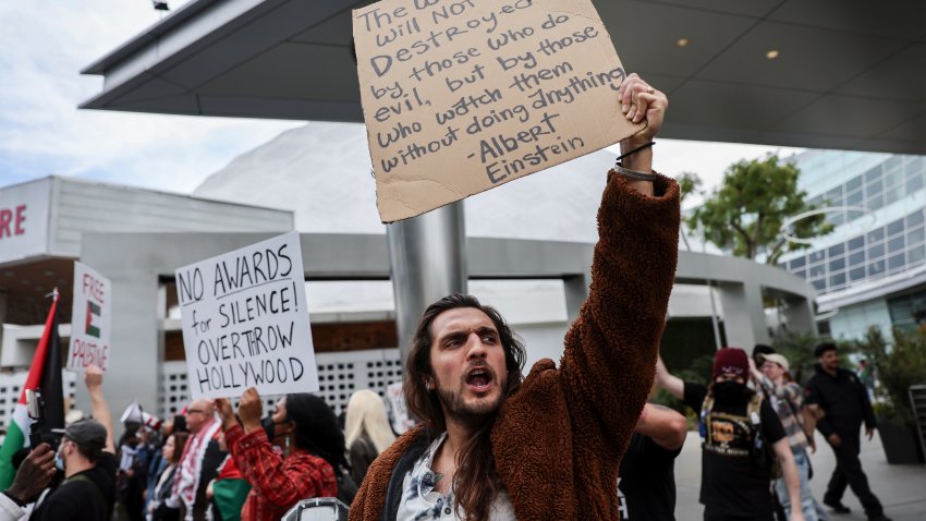 Protesters hold posters during a demonstration in support of Palestinians calling for a ceasefire in Gaza as the 96th Academy Awards Oscars ceremony is held nearby, Sunday, March 10, 2024