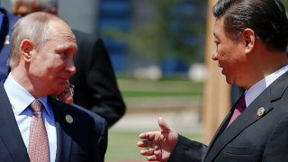 Chinese President Xi Jinping speaks with Russian President Vladimir Putin as leaders gather for a family photo during the Belt and Road Forum on Yanqi Lake, outside Beijing, China, May 15, 2017.