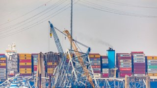 Debris is cleared from the collapsed Francis Scott Key Bridge as efforts begin to reopen the Port of Baltimore on March 31, 2024, in Baltimore, Maryland. 