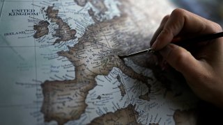 An artist paints a globe at a studio in London, Tuesday, Feb. 27, 2024.