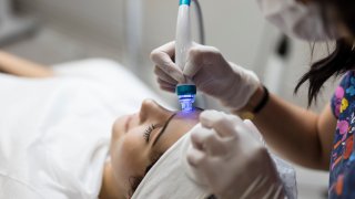 Cosmetologist making mesotherapy injection with dermapen on face