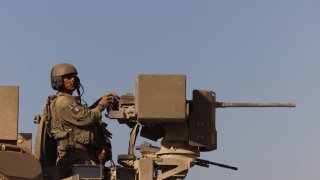 An Israeli soldier mans the machine gun on a tank near the Gaza border after military operations, in southern Israel, on Wednesday.