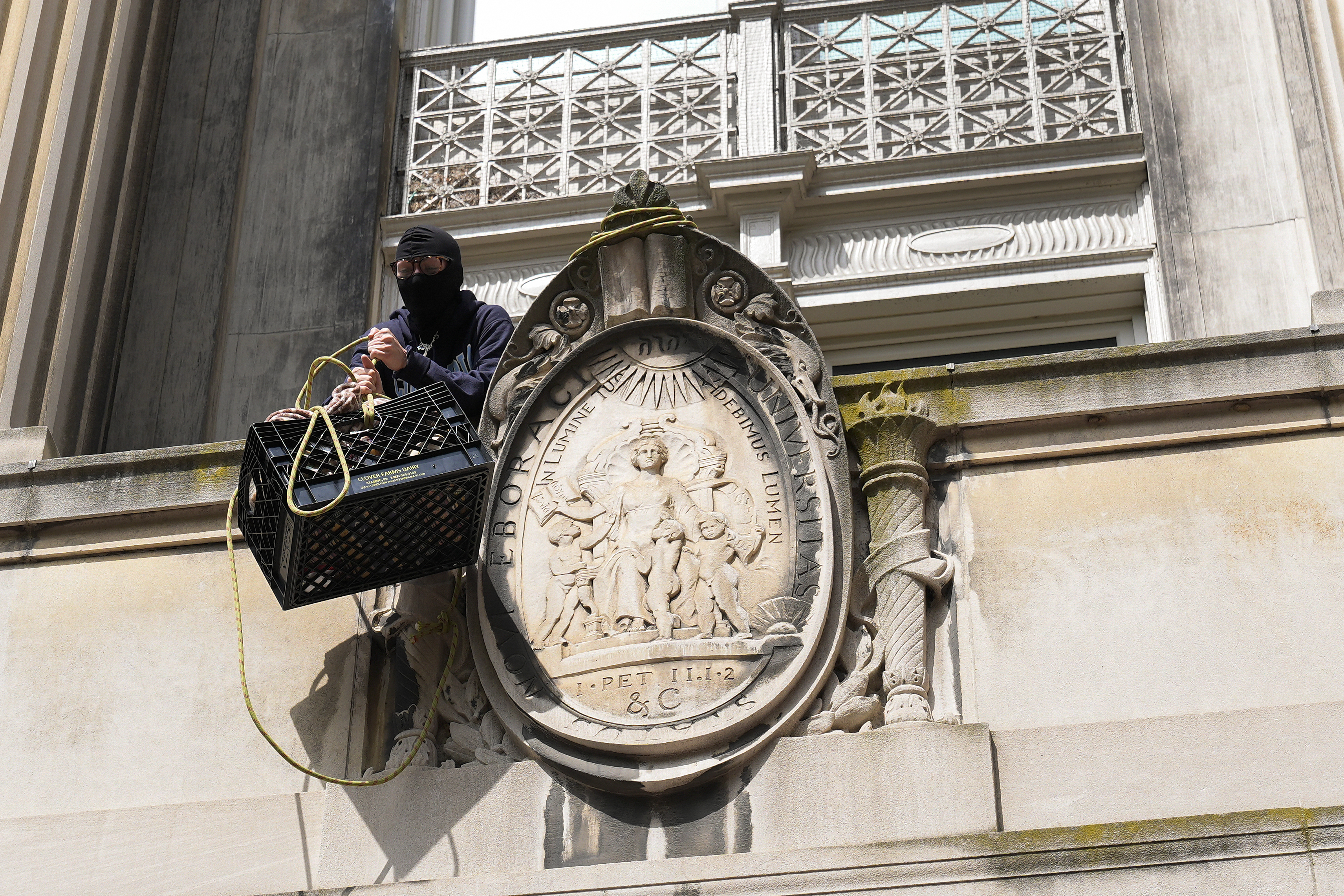 NEW YORK, NEW YORK – APRIL 30: A student protester pulls up a crate filled with foot and supplies from a balcony of Hamilton Hall on the campus of Columbia University on April 30, 2024 in New York City. All classes at Columbia University have been held virtually today after school President Minouche Shafik announced a shift to online learning in response to recent campus unrest. (Photo by Mary Altaffer-Pool/Getty Images)