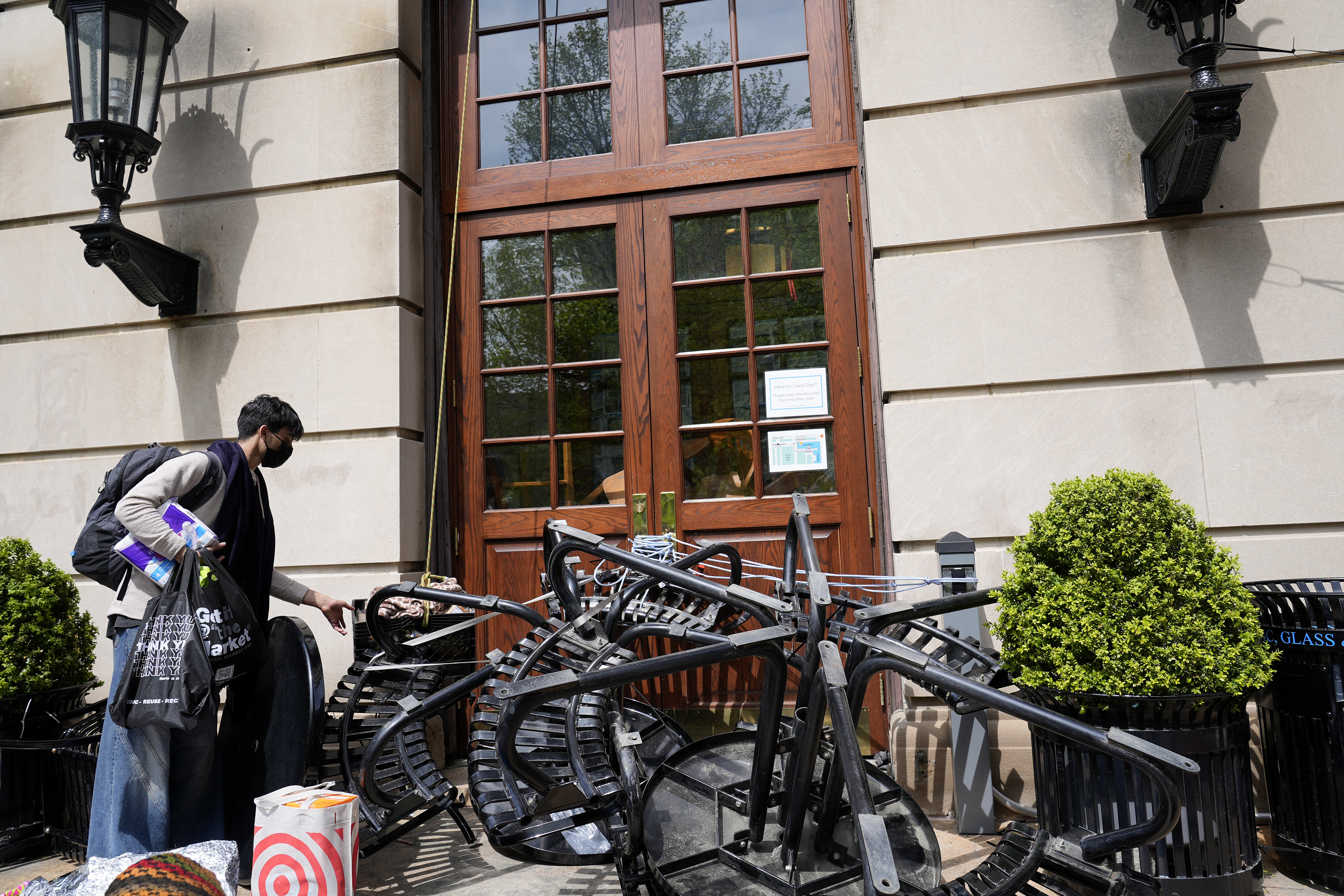 NEW YORK, NEW YORK – APRIL 30: A Student protestor drops trash in a bin where benches and trash bins block the entrance to Hamilton Hall on the campus of Columbia University on April 30, 2024 in New York City. All classes at Columbia University have been held virtually today after school President Minouche Shafik announced a shift to online learning in response to recent campus unrest. (Photo by Mary Altaffer-Pool/Getty Images)