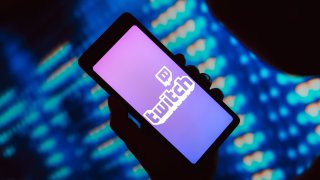 In this photo illustration, the Twitch logo is displayed on a smartphone screen. 