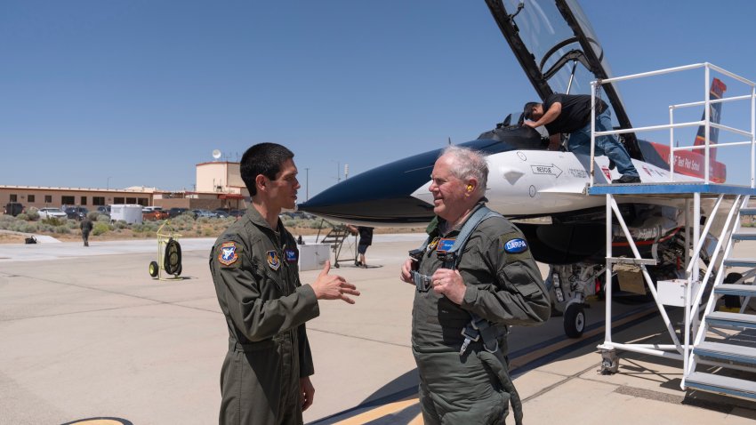 Air Force Secretary Frank Kendall, right, talks to Col. James Valpiani, Commandant, USAF TPS, after Kendall’s test flight of the X-62A VISTA aircraft against a human-crewed F-16 aircraft in the skies above Edwards Air Force Base, Calif., on Thursday, May 2, 2024. The flight is serving as a public statement of confidence in the future role of AI in air combat. The military is planning to use the technology to operate an unmanned fleet of 1,000 aircraft.