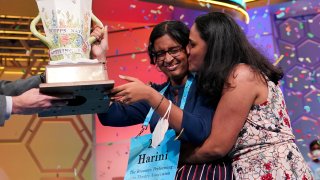 Harini Logan, 14, from San Antonio, Texas, gets a kiss from her mom Rampriya Logan on stage as she celebrates winning the Scripps National Spelling Bee, Thursday, June 2, 2022, in Oxon Hill, Md.